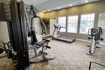 A gym with exercise equipment on the floor and windows